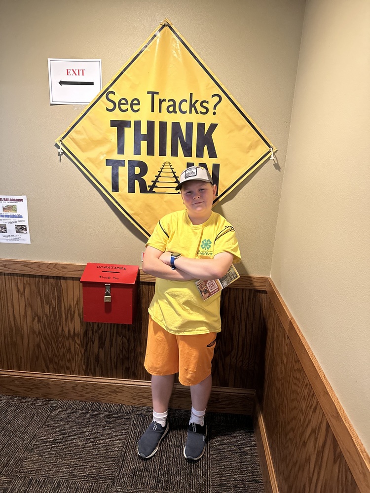 North Middle School Student Sam Mahon Poses In Front of Railroad Safety Sign 