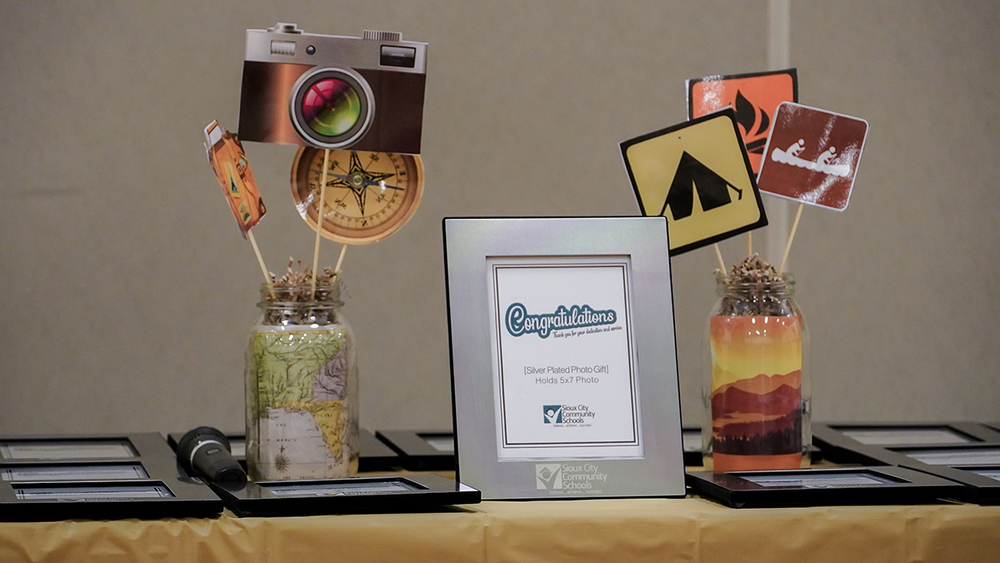 Image from 2023 retirement party. Image shows two "adventure" themed centerpieces surrounding a retirement picture frame.