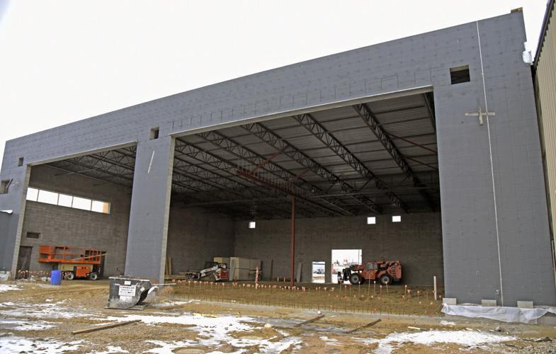 A large concrete building with dirt floors, with two open hangar style doors unfinished