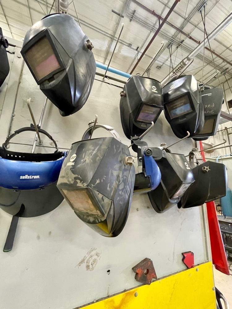 welding helmets hanging on a wall