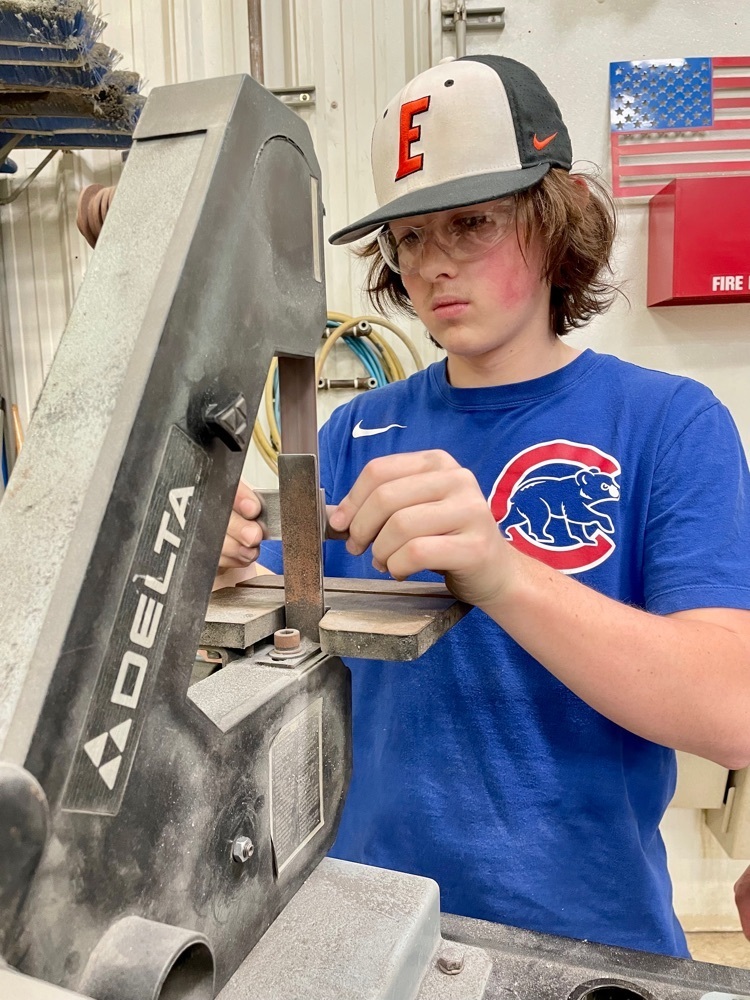 male student using an electric belt sander