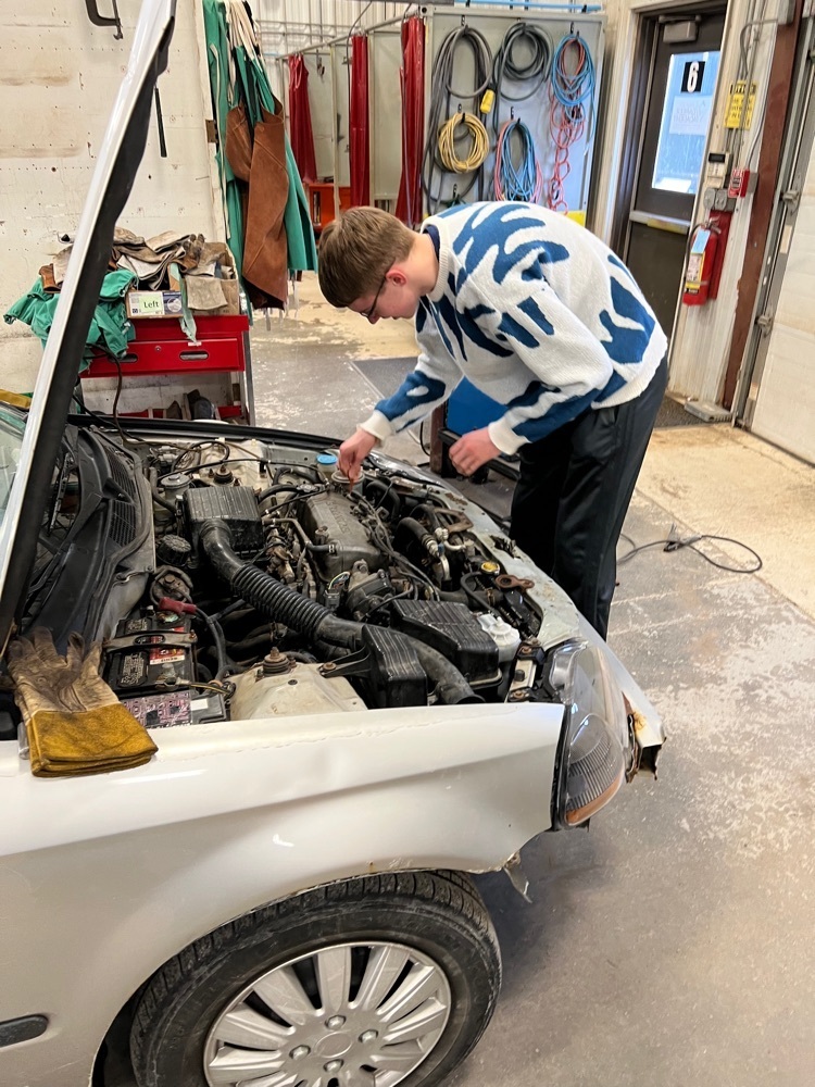 student working on his car